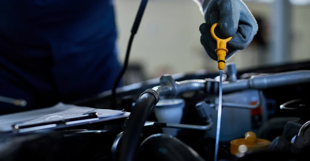closeup_auto_repairman_checking_car_oil_workshop