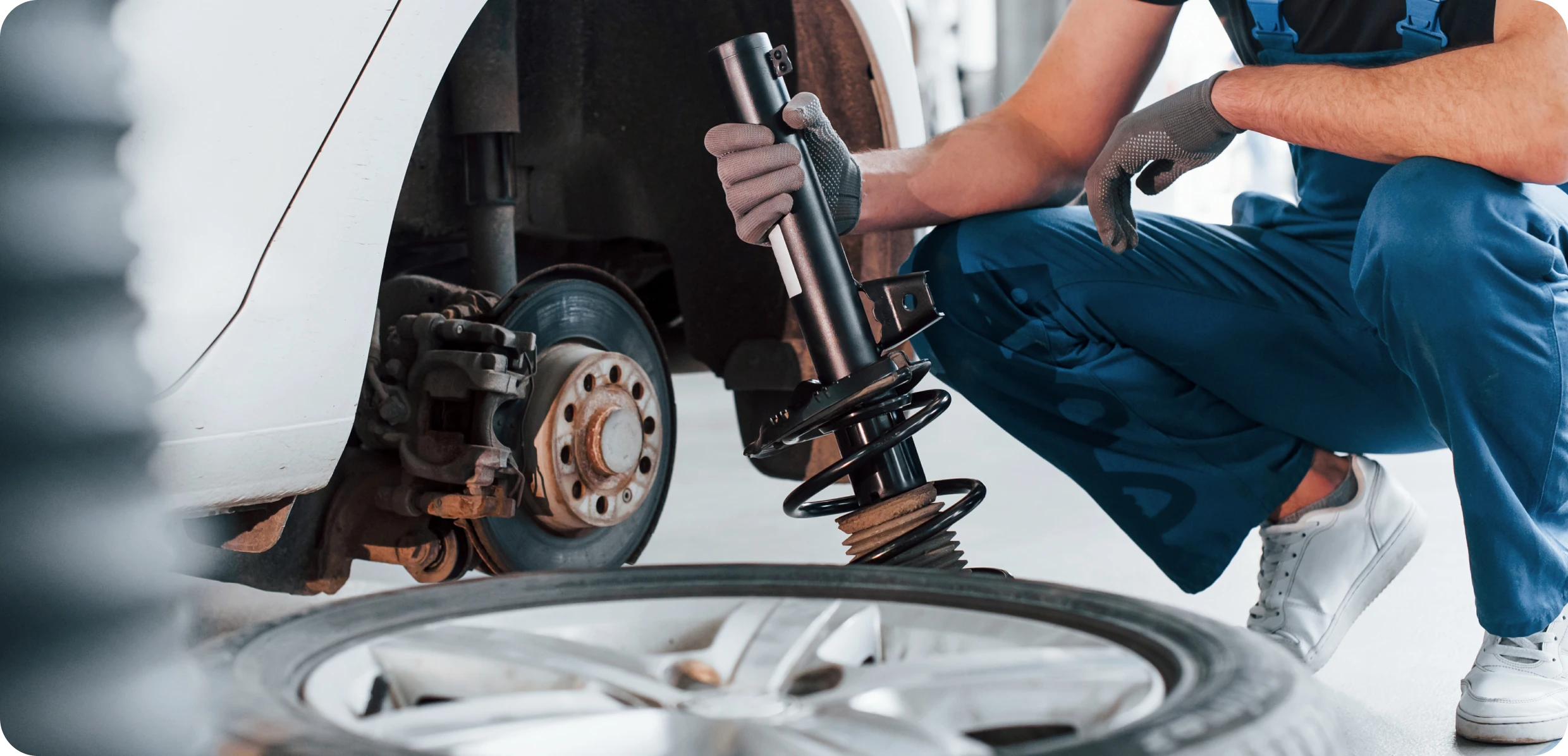 A man works on changing a tire on a vehicle in an auto repair facility in Houston.