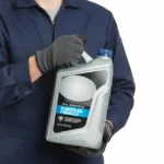 Mechanic holding a container of european synthetic motor oil.