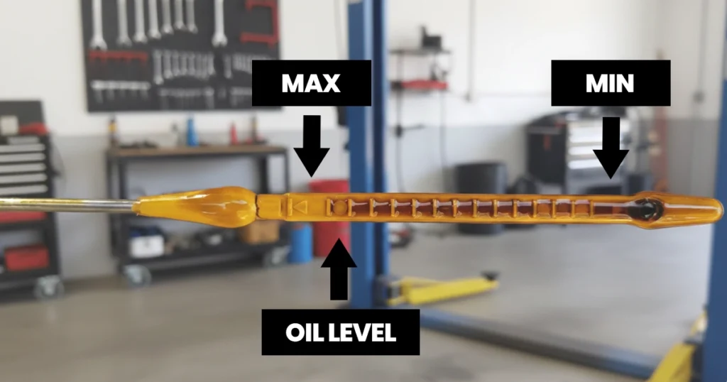 Close-up of a car oil dipstick showing oil level markers.
