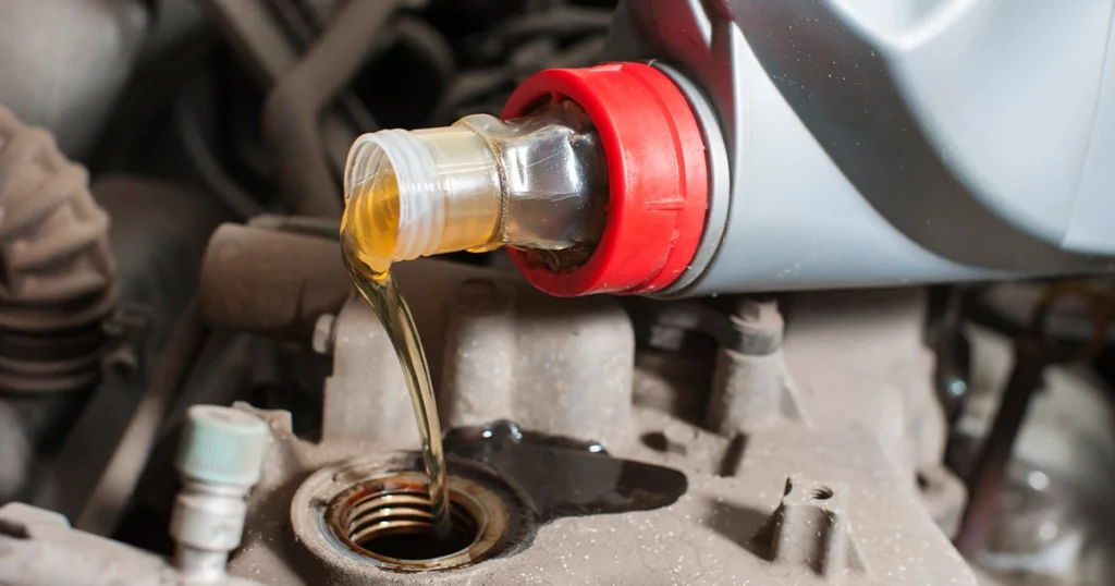 Pouring the correct engine oil into a car engine.