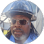 A man with dreadlocks, wearing a hat and sunglasses, reviews services at Eric's Car Care.