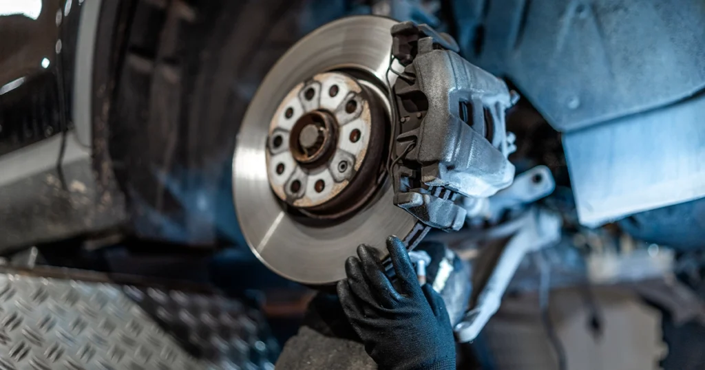 Mechanic inspecting brake rotor following safety checklist