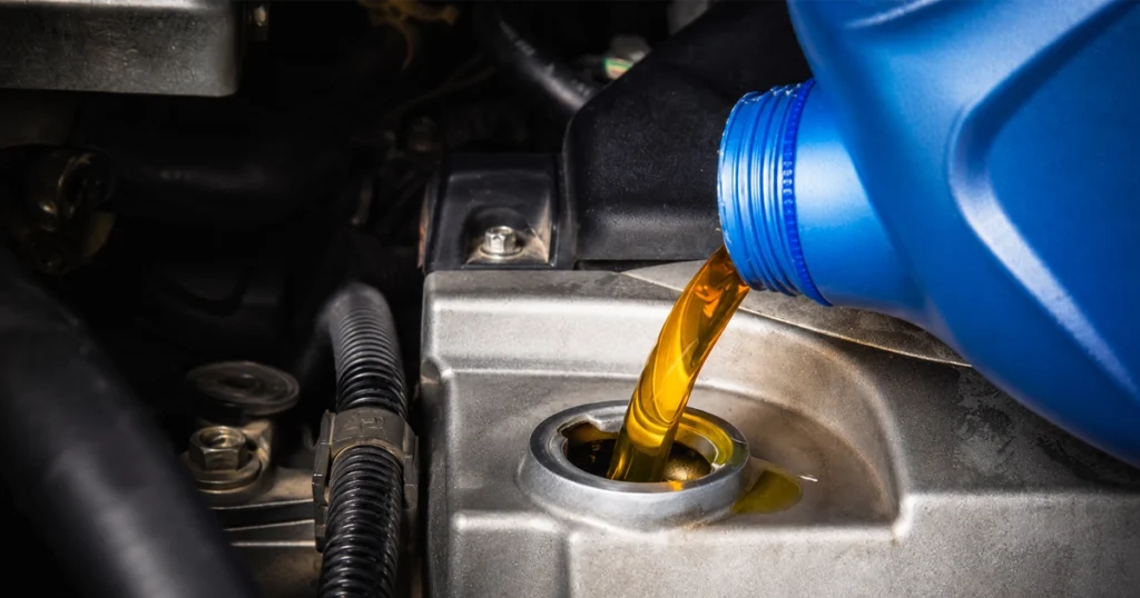 Golden motor oil being poured into a car engine.