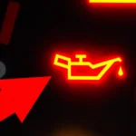 Red engine oil warning light illuminated on a car dashboard.