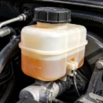 Brake fluid reservoir under a car hood showing fluid level markings.