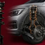 A car suspension strut shown isolated and installed within a vehicle's wheel assembly.