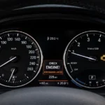 Car dashboard displaying an illuminated check engine warning.