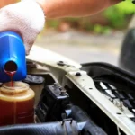 Mechanic pouring automotive fluid into a reservoir.