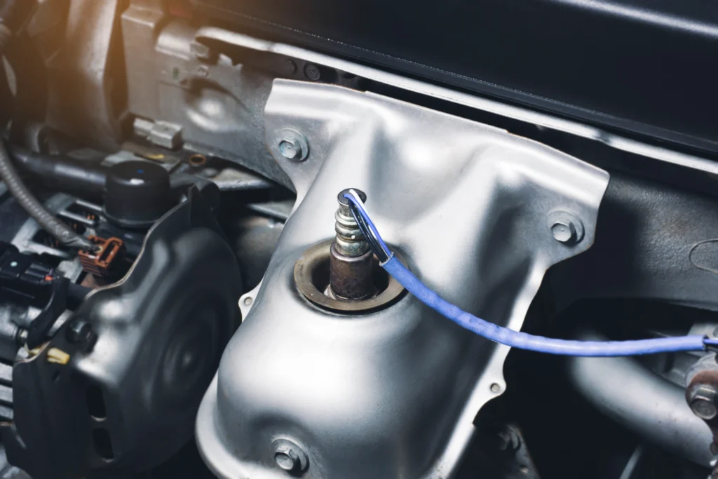 Close-up of an oxygen sensor installed in a car engine bay