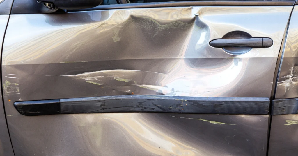 Severely dented car door needing repair