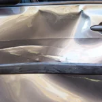 Severely dented car door needing repair
