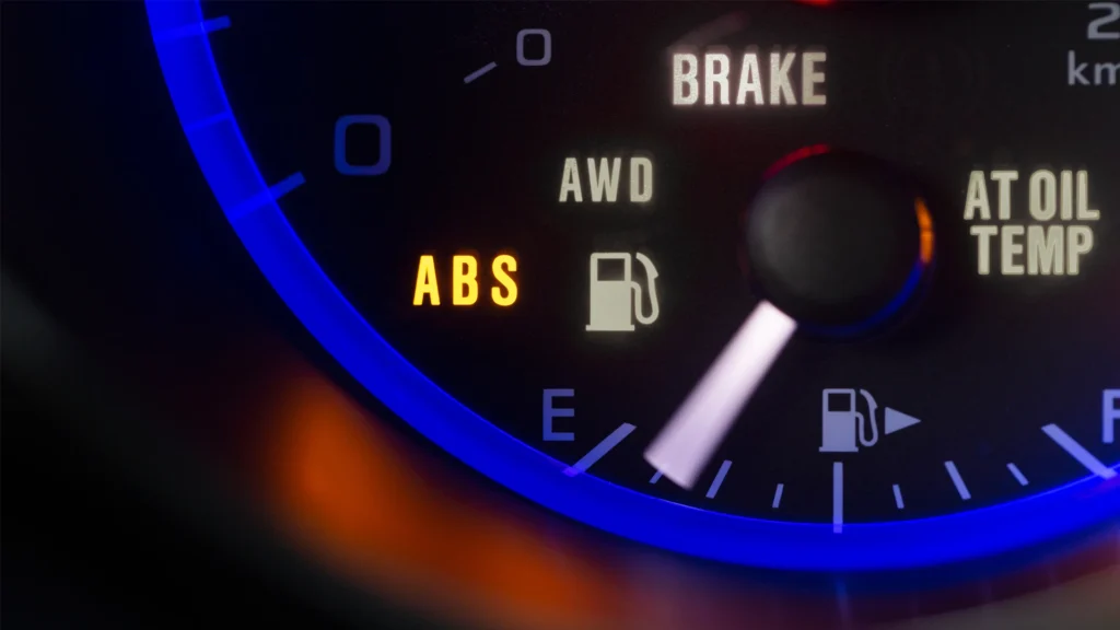 A close-up view of a car dashboard showing illuminated ABS and warning lights